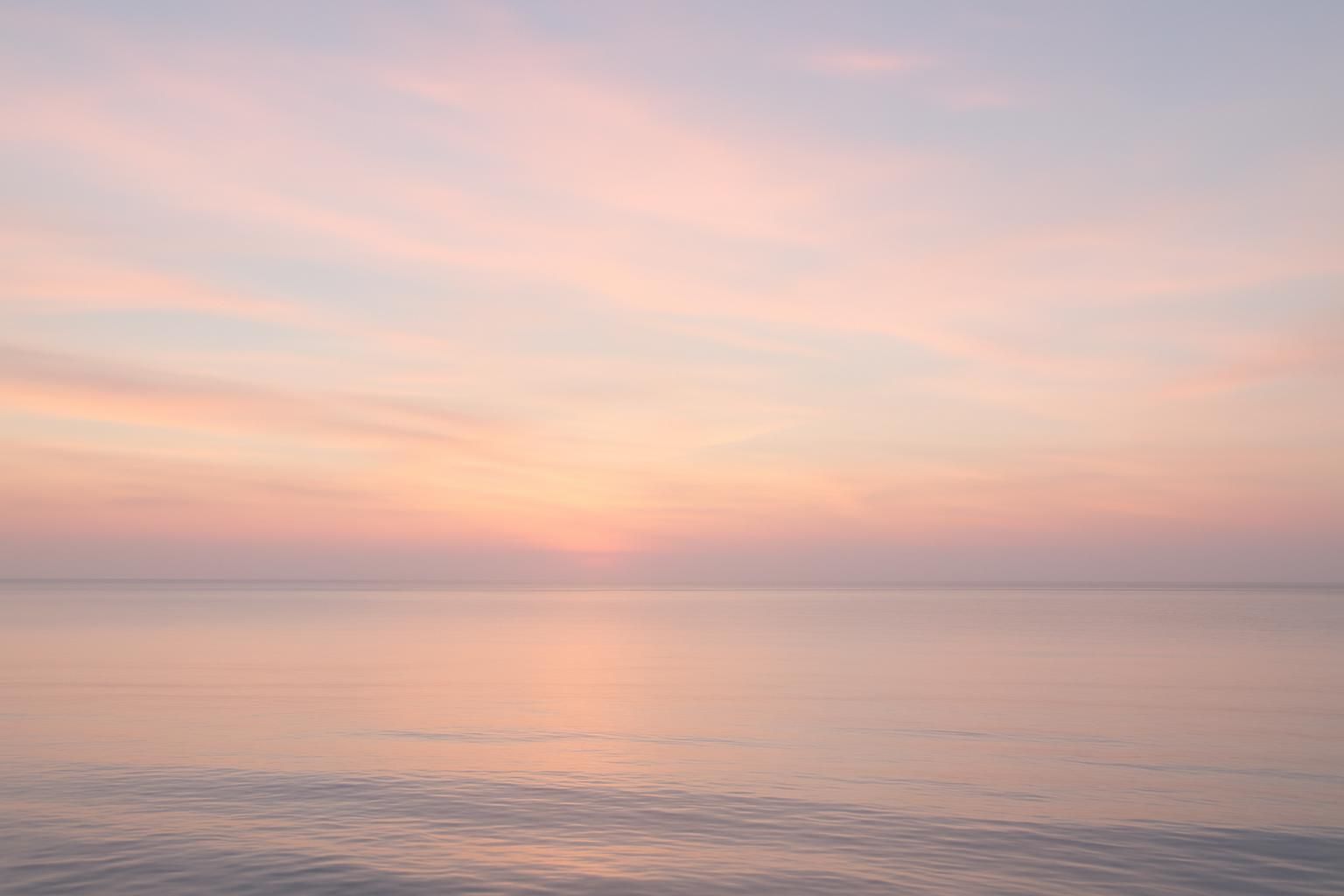 A soft pastel sky over a calm gulf horizon near Houston, TX